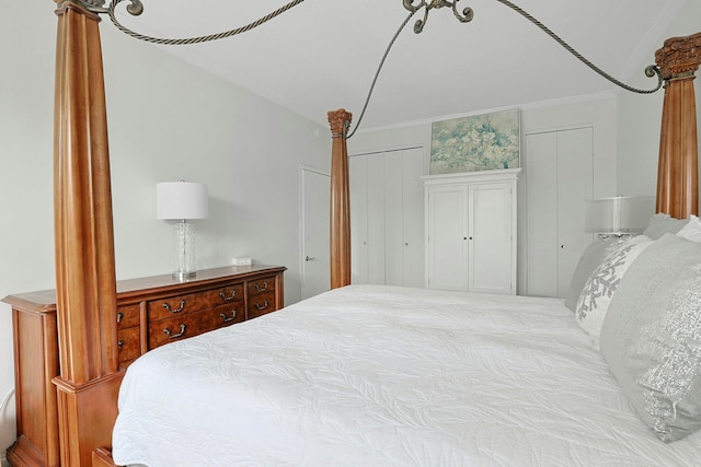 bedroom with multiple closets and ornamental molding