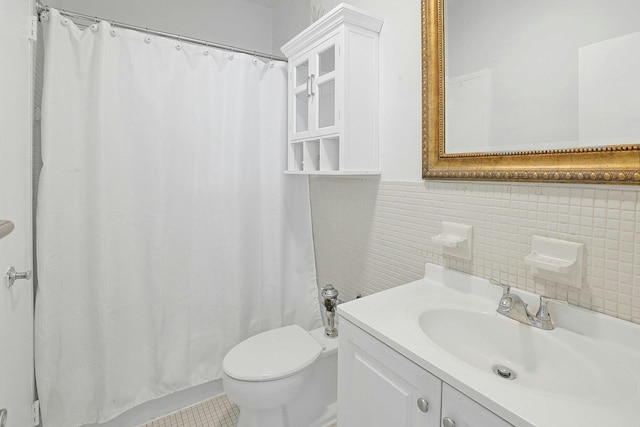 bathroom with tile walls, toilet, vanity, curtained shower, and wainscoting