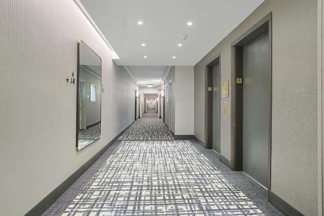 hallway with elevator, recessed lighting, baseboards, and carpet floors