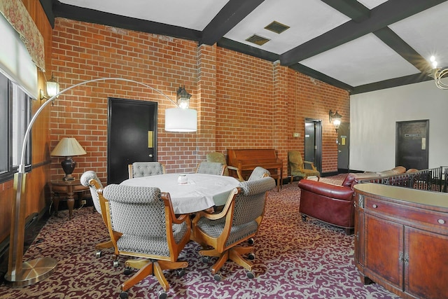 dining room featuring brick wall and beam ceiling
