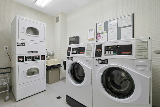 shared laundry room with washing machine and dryer, stacked washer and clothes dryer, and light tile patterned floors