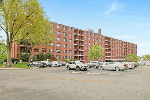 view of apartment building / complex with uncovered parking