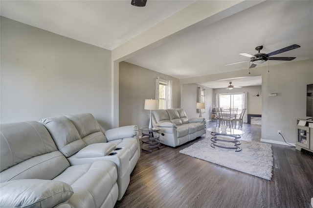 living room with healthy amount of natural light, dark wood finished floors, baseboards, and ceiling fan