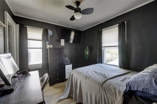 bedroom featuring light wood-style floors, ornamental molding, and ceiling fan