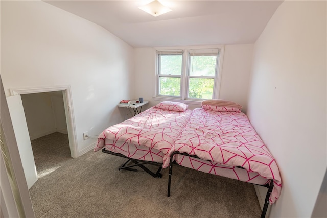 carpeted bedroom featuring lofted ceiling and baseboards