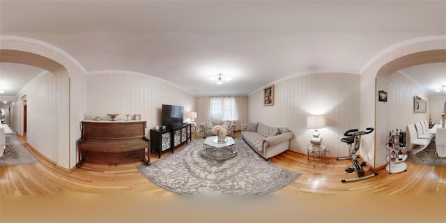 living room with crown molding, wood finished floors, and arched walkways