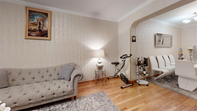 interior space with arched walkways, ornamental molding, and wood finished floors