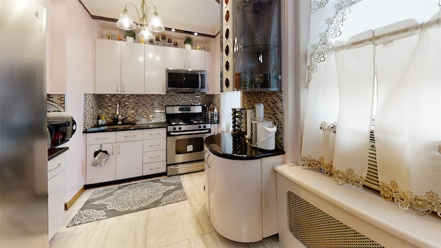 kitchen featuring white cabinetry, decorative backsplash, dark countertops, and appliances with stainless steel finishes