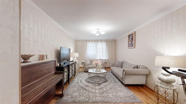 living area with wallpapered walls, wood finished floors, and ornamental molding