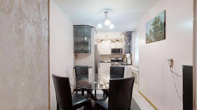 dining area with an inviting chandelier and ornamental molding