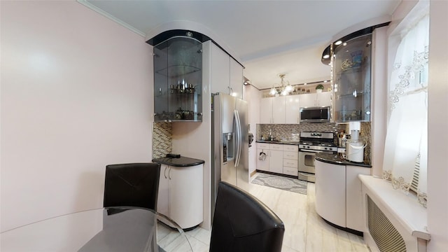 kitchen featuring glass insert cabinets, dark countertops, white cabinetry, appliances with stainless steel finishes, and tasteful backsplash