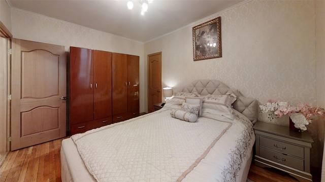 bedroom featuring ornamental molding, a closet, and hardwood / wood-style floors