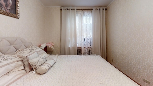 bedroom featuring crown molding and wallpapered walls