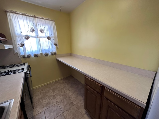 kitchen featuring gas range oven, light countertops, and extractor fan