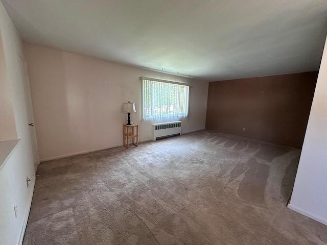 carpeted spare room featuring radiator