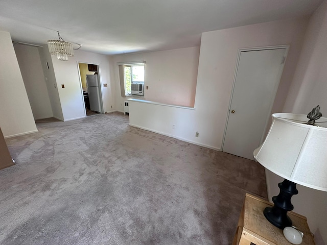 unfurnished living room with radiator, carpet flooring, cooling unit, baseboards, and a chandelier