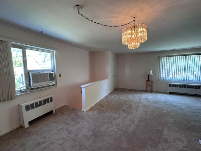 carpeted spare room with radiator heating unit, a chandelier, and cooling unit