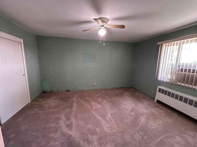 unfurnished room with radiator, a ceiling fan, and carpet floors
