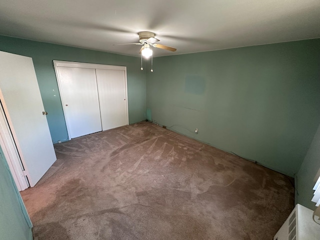 unfurnished bedroom with carpet, a closet, and a ceiling fan