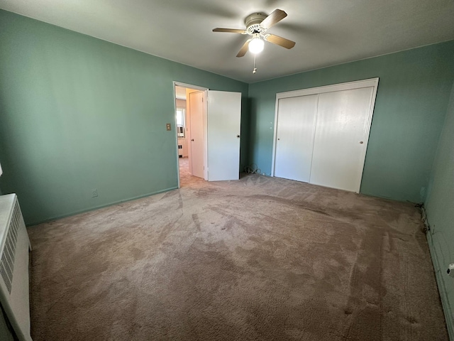 unfurnished bedroom with carpet, a closet, and a ceiling fan