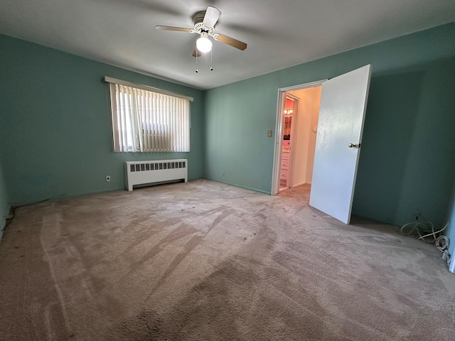 carpeted empty room with radiator heating unit and ceiling fan