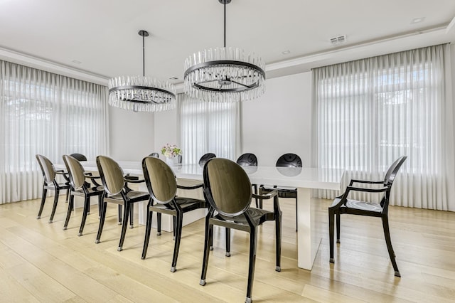 dining room with a notable chandelier, light wood finished floors, and visible vents
