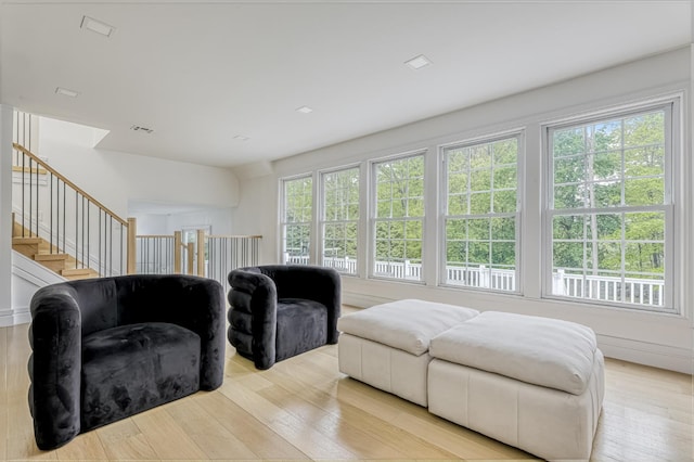 living area with light wood-type flooring and stairway