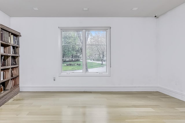 empty room with baseboards and light wood-style floors