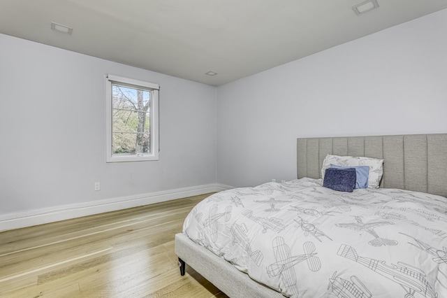 bedroom with wood finished floors and baseboards