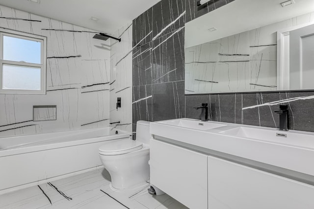 bathroom with double vanity, toilet, shower / washtub combination, tile walls, and marble finish floor