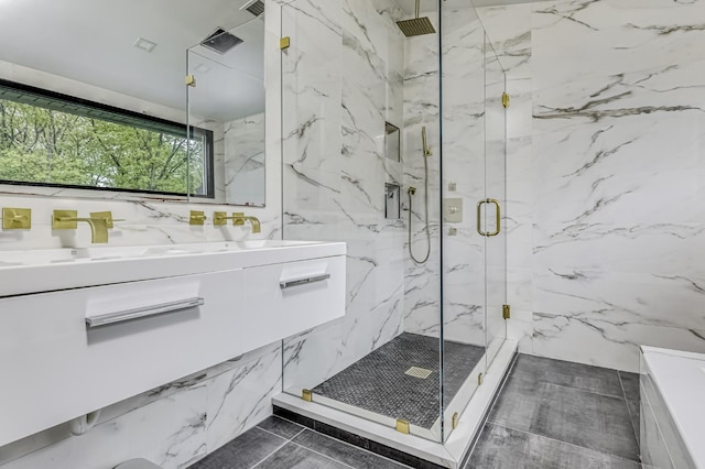 full bath with a marble finish shower and double vanity