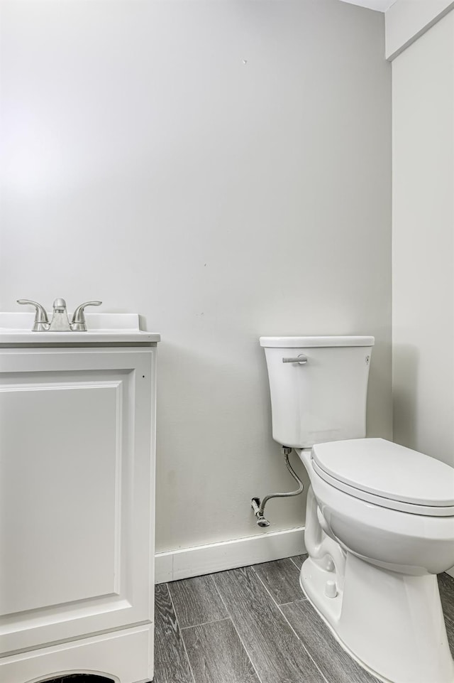 bathroom featuring baseboards, toilet, and wood tiled floors