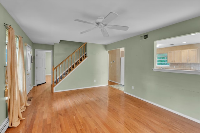534 Puritan Dr, Shirley, NY 11967 - unfurnished living room featuring a baseboard radiator, a ceiling fan, light wood-style flooring, and baseboards