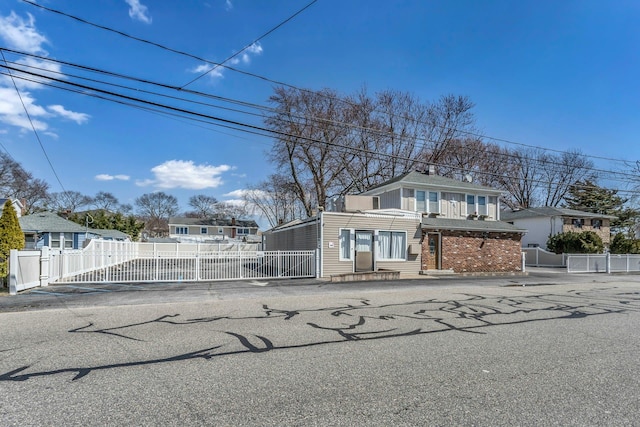 view of front of house featuring brick siding, a gate, and fence private yard