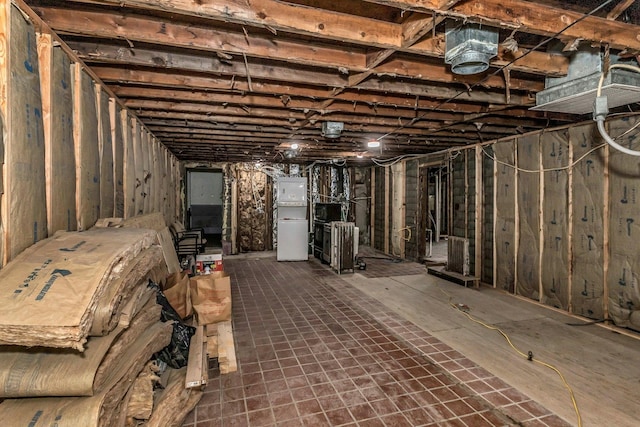 unfinished basement featuring refrigerator
