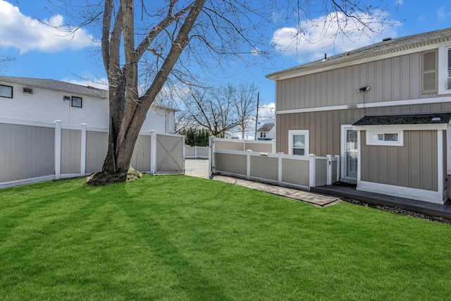 view of yard with a fenced backyard and a gate