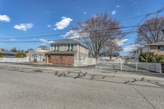 view of front of property with brick siding and fence