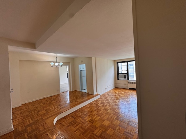 9825 64th Rd Unit 5F, Rego Park, NY 11374 - empty room with radiator heating unit, a chandelier, baseboards, and cooling unit