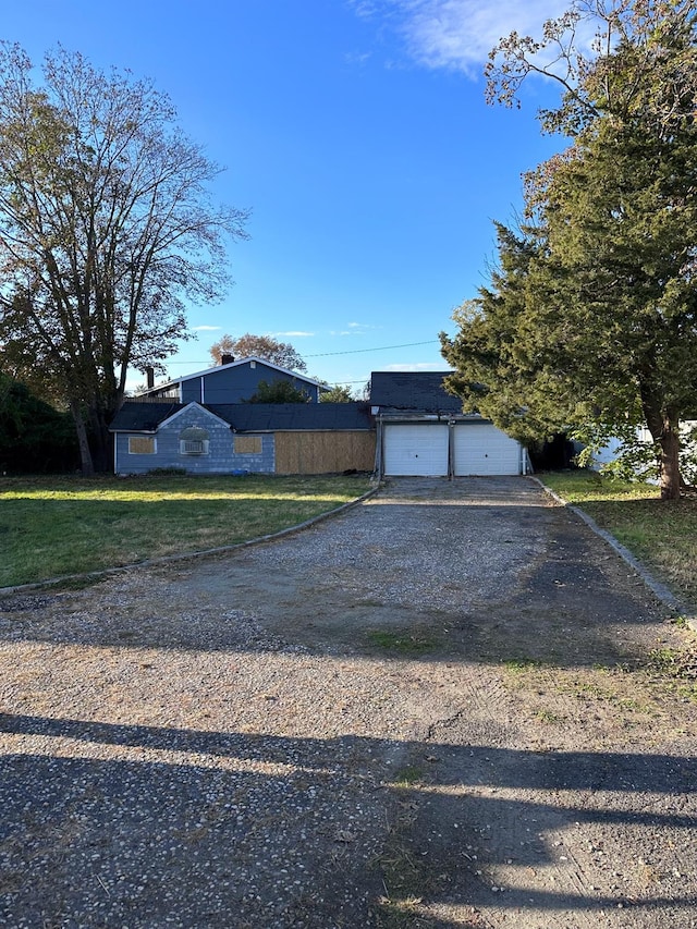 view of front of property featuring dirt driveway and a garage