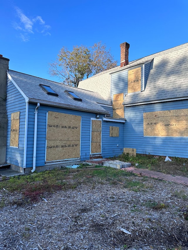 rear view of property with a chimney