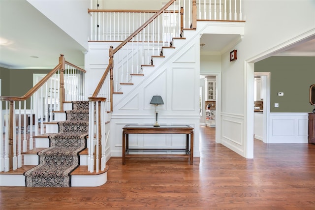 7 Viola Ct, Wappingers Falls, NY 12590 - stairway featuring a decorative wall, ornamental molding, wood finished floors, a towering ceiling, and a wainscoted wall