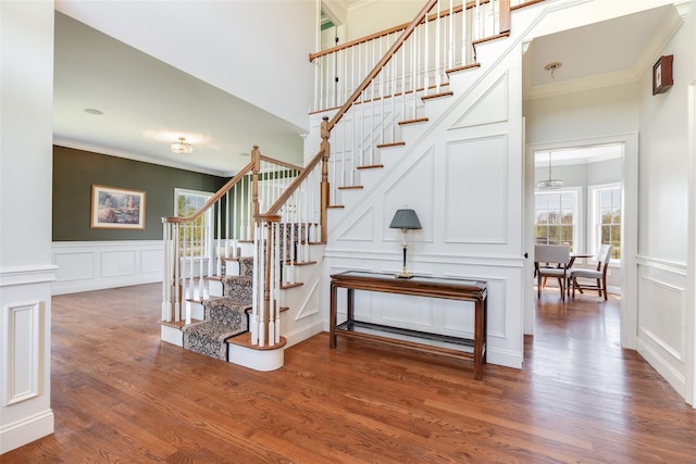 7 Viola Ct, Wappingers Falls, NY 12590 - stairs with a decorative wall, crown molding, wood finished floors, a wainscoted wall, and a high ceiling