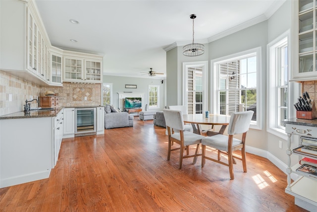 7 Viola Ct, Wappingers Falls, NY 12590 - dining space with beverage cooler, plenty of natural light, light wood-style flooring, ceiling fan, and crown molding