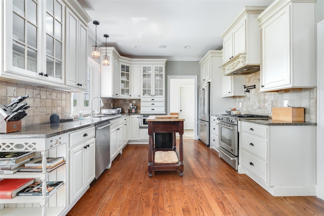 7 Viola Ct, Wappingers Falls, NY 12590 - kitchen featuring high quality appliances, under cabinet range hood, decorative backsplash, glass insert cabinets, and white cabinetry