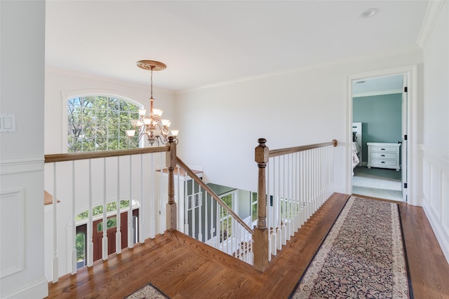 7 Viola Ct, Wappingers Falls, NY 12590 - hallway featuring a chandelier, wood finished floors, crown molding, an upstairs landing, and a wainscoted wall