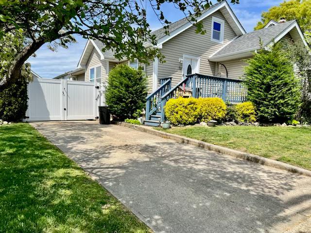 view of home's exterior with a gate, concrete driveway, and a lawn