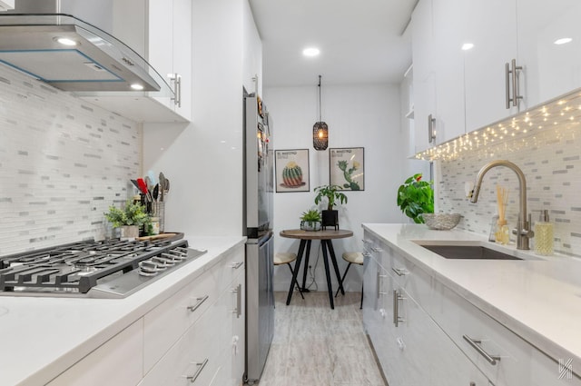 kitchen with range hood, a sink, appliances with stainless steel finishes, backsplash, and recessed lighting