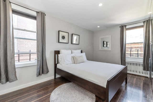bedroom featuring radiator, dark wood finished floors, baseboards, and recessed lighting