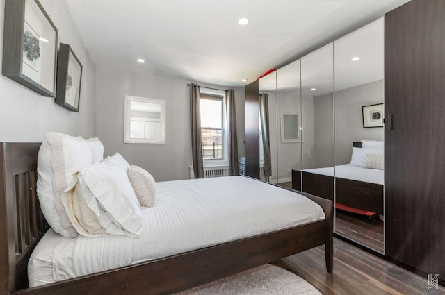 bedroom with wood finished floors, recessed lighting, and a closet