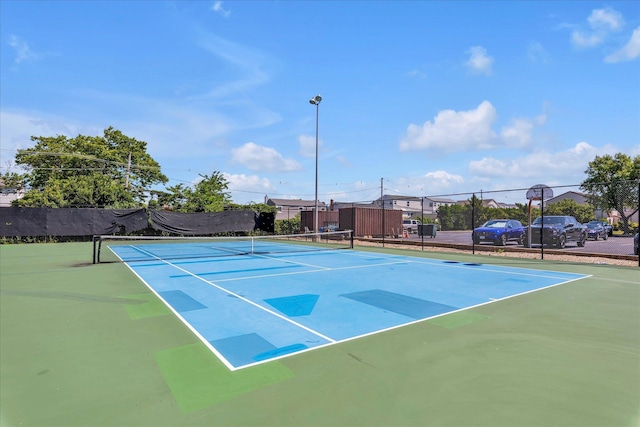 view of tennis court featuring fence